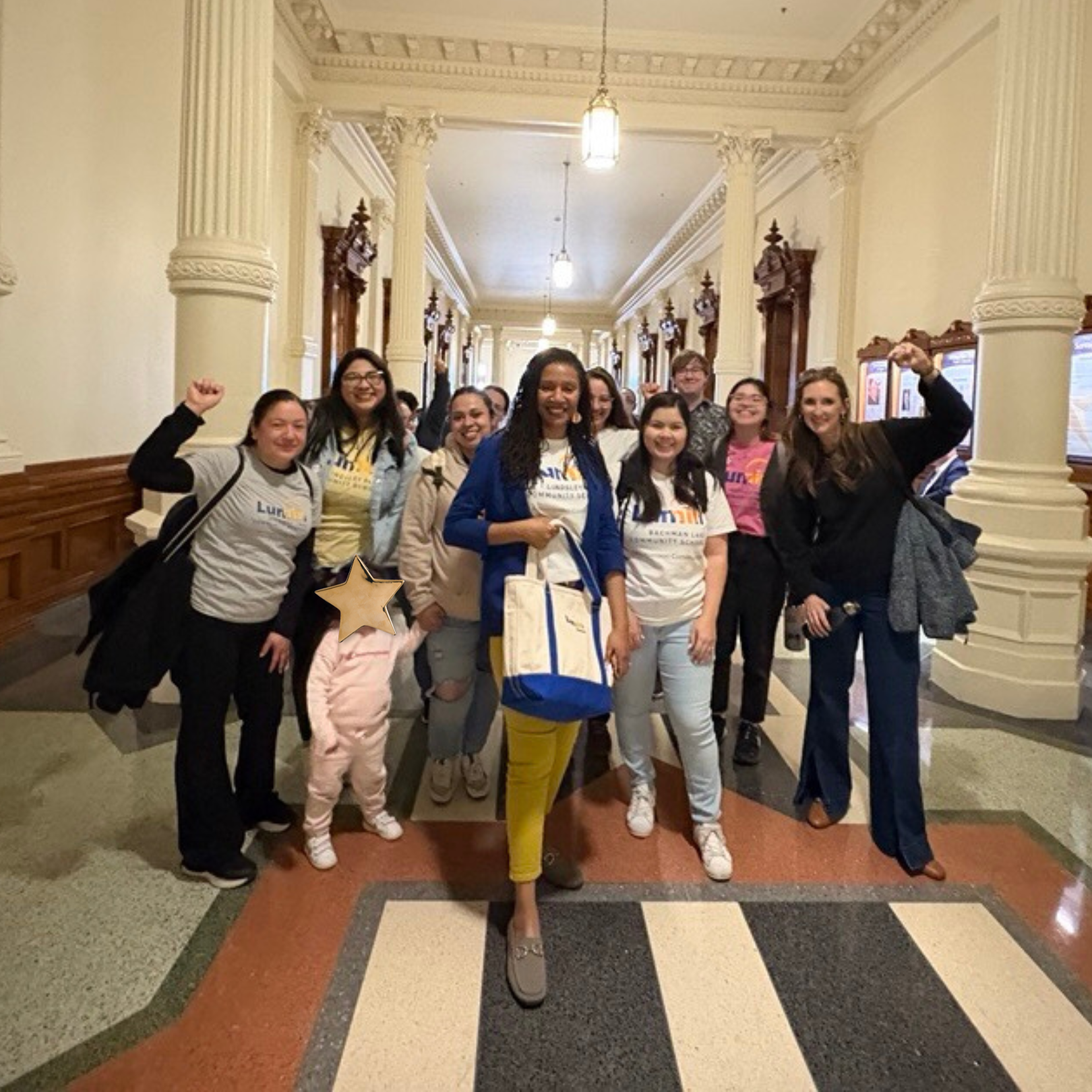 Group of smiling advocates posing together in a historic hallway, showing support for early childhood education initiatives.
